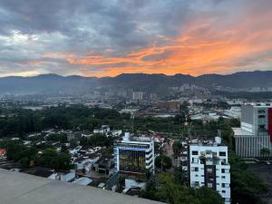 un perfil urbano al atardecer con montañas al fondo en Suite - Go living & Suites, en Medellín