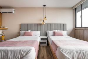 dos camas sentadas una al lado de la otra en una habitación en Suite - Go living & Suites, en Medellín