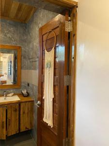 a bathroom with a wooden door and a sink at UNWND BOUTIQUE HOTEL CALATAGAN in Batangas City