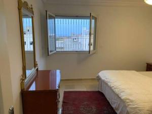 - une chambre avec un lit, une fenêtre et un miroir dans l'établissement New 3 bedroom condo/plenty parking/15 min to Tunis, à Fouchana