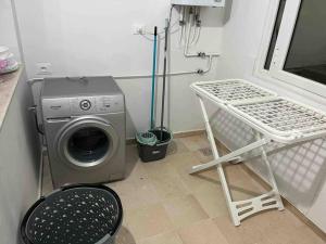 a washing machine in a laundry room with a washer at New 3 bedroom condo/plenty parking/15 min to Tunis in Fouchana