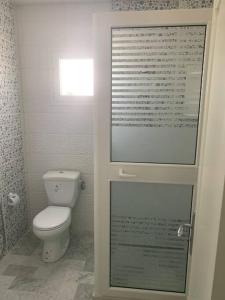a bathroom with a white toilet and a window at New 3 bedroom condo/plenty parking/15 min to Tunis in Fouchana