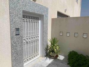 um portão no lado de um edifício com uma planta em New 3 bedroom condo/plenty parking/15 min to Tunis em Fouchana