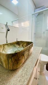 łazienka z dużą kamienną umywalką na ladzie w obiekcie Apê Campeche w mieście Florianópolis