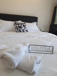 Una cama blanca con un letrero hecho en ella en 3Storey House 13Pax Family Suite, en Bayan Lepas