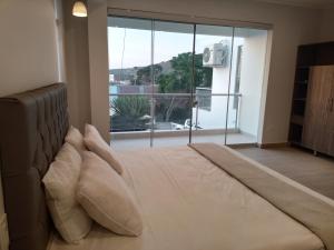 1 dormitorio con 1 cama grande y ventana grande en Silver Inn Hotel en Cerro Azul