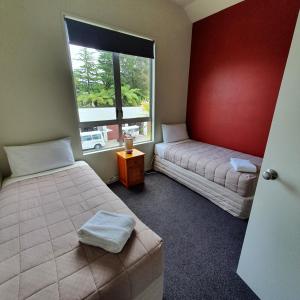 um quarto com 2 camas e uma janela em Kuirau Chalet Villa 3-bedroom Twin Lake em Rotorua