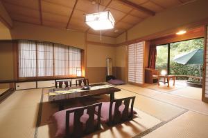 a living room with a table and chairs at Kirishima Momijidani Seiryuso in Kirishima