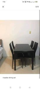 een zwarte eettafel met vier zwarte stoelen bij HI RESIDENCES in Bacolod