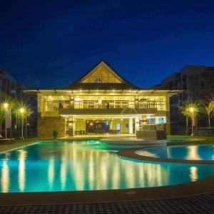 een groot gebouw met een zwembad in de nacht bij HI RESIDENCES in Bacolod