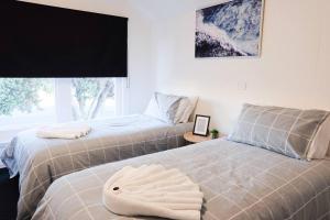 dos camas sentadas una al lado de la otra en un dormitorio en Kepler House in City Centre, en Warrnambool