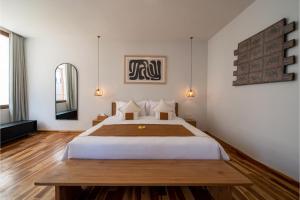 um quarto com uma cama grande e piso em madeira em Green Villa Canggu em Canggu