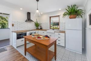 une cuisine avec une table en bois et un réfrigérateur blanc dans l'établissement Maleny Town Stay, à Maleny 5 autres photos