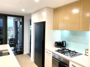 a kitchen with a stove top oven next to a counter at Serenity Splendour at Darwin Waterfront in Darwin