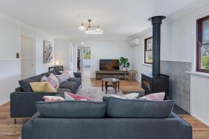 a living room with two couches and a fireplace at Maleny Town Stay in Maleny