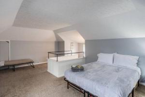 Un dormitorio con una cama grande y un banco en Astonishing Home Mins Away Airport/Dwtn/UofR/RIT, en Rochester