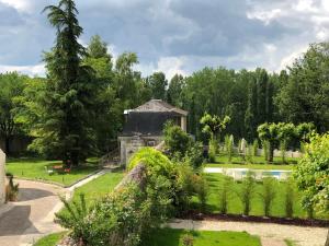 um jardim com uma casa de pedra e um lago em Cottage Jardin Duplex of 70 m² for 2 people – 1 bedroom – 2 bathrooms – em Azay-le-Rideau