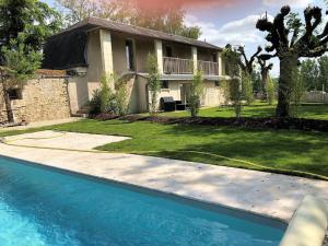 uma casa com piscina em frente a uma casa em Cottage Jardin Duplex of 70 m² for 2 people – 1 bedroom – 2 bathrooms – em Azay-le-Rideau