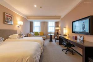 um quarto de hotel com duas camas e uma televisão de ecrã plano em SSAW Boutique Hotel Hangzhou East em Hangzhou