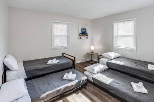 a room with three beds and two windows at Modern & Quiet Suburban Ranch Mins to Dtwn/Stores 