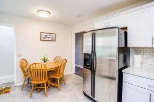 a kitchen with a table and a refrigerator at Modern & Quiet Suburban Ranch Mins to Dtwn/Stores 