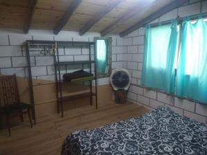 a bedroom with a bunk bed and a fan at cabañas rio y playa 2 in Atos Pampa