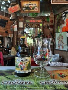 a bottle of chowder and a wine glass on a table at Pai River Jam Hostel & Campground in Pai