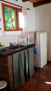 cocina con fregadero y nevera en Duplex Luna en Lago Puelo