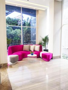 泗水Surabaya River View Hotel的配有大窗户的客房内的粉红色沙发 更多35张照片