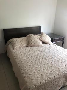 uma cama com duas almofadas num quarto em El Oasis Fomeque em Fómeque