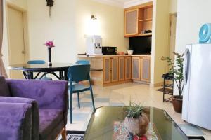 a kitchen and living room with a purple couch and a table at Lotus Desaru Beach Resort, 2 bdrms, w/splash park in Bandar Penawar