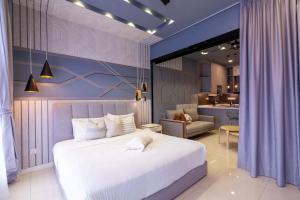 een slaapkamer met een groot wit bed en een keuken bij HighPark Suites in Petaling Jaya, Kelana Jaya by Plush in Kampong Baharu Sungai Way