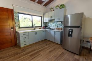 a kitchen with a stainless steel refrigerator and white cabinets at Beach Apartment Villas Jubey, Emotion access in Juan Dolio