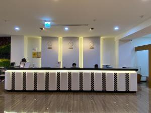 a lobby with two people sitting at a reception desk at San Juan Easy Stay Inn Tainan in Tainan