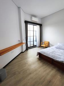 a bedroom with a bed and a large window at Beautiful House in City Centre in Kanggraksan