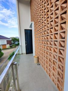 a wall of wood panels on a balcony with a door at Beautiful House in City Centre in Kanggraksan