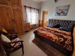um quarto com uma cama grande e uma cadeira em Vacay Datcha em Kūd