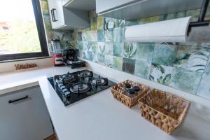 a kitchen with a stove and baskets on the counter at Beach Apartment Villas Jubey, Emotion access in Juan Dolio