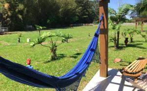 a blue hammock in a yard with a field at Pousada Haras Trevo de Ferro, Praia, Piscina e Campo in Torres