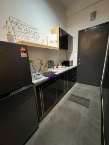 八打靈再也的住宿－Breeze Cottage@Empire Damansara，厨房配有黑色冰箱和台面