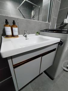 a bathroom sink with two bottles on top of it at Breeze Cottage@Empire Damansara in Petaling Jaya