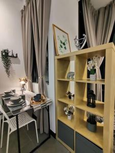 una habitación con una mesa y un estante de libros en Breeze Cottage@Empire Damansara en Petaling Jaya