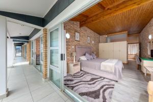 a bedroom with a bed in a room with glass doors at Vic Bay Beach House in Victoria Bay
