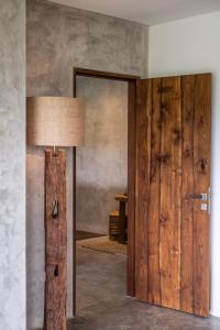 Habitación con puerta de madera y lámpara. en Hidden Gem Suites Ubud en Ubud