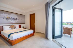 1 dormitorio con 1 cama y puerta corredera de cristal en The Present River Villa Hoi An en Hoi An