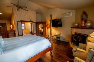 a bedroom with a bed and a fireplace and a chair at Albergo Allegria Hotel & Breakfast Restaurant in Windham
