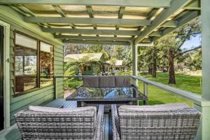 a patio with two chairs and a table on a porch at Beau Cabin One Bedroom Cabin on Golf Course in Kangaroo Valley