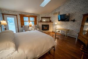 a bedroom with a large bed and a fireplace at Albergo Allegria Hotel & Breakfast Restaurant in Windham