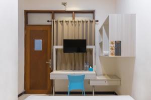 Habitación con escritorio y silla azul. en Twospaces Living at Kertajaya Residence, en Bagongsabrangan
