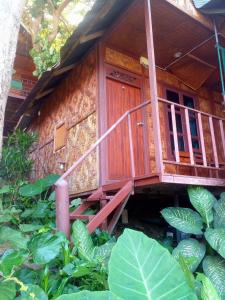 uma casa de madeira com uma escada no meio de um jardim em PP Natural Hill em Phi Phi Don